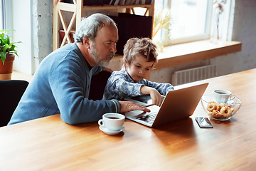 Image showing Grandfather and his grandson spending time insulated at home, stadying, watching cinema, shopping together