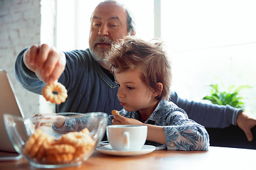 Image showing Grandfather and his grandson spending time insulated at home, stadying, watching cinema, shopping together