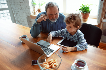 Image showing Grandfather and his grandson spending time insulated at home, stadying, watching cinema, shopping together