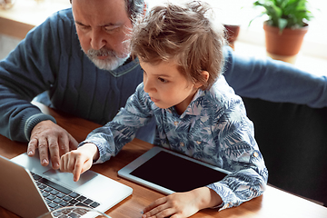 Image showing Grandfather and his grandson spending time insulated at home, stadying, watching cinema, shopping together