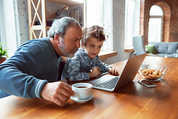 Image showing Grandfather and his grandson spending time insulated at home, stadying, watching cinema, shopping together