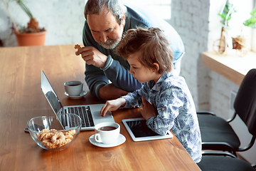 Image showing Grandfather and his grandson spending time insulated at home, stadying, watching cinema, shopping together