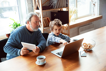 Image showing Grandfather and his grandson spending time insulated at home, stadying, watching cinema, shopping together