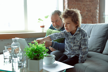 Image showing Grandfather and his grandson spending time insulated at home, stadying, watching cinema, shopping together