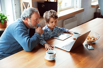 Image showing Grandfather and his grandson spending time insulated at home, stadying, watching cinema, shopping together