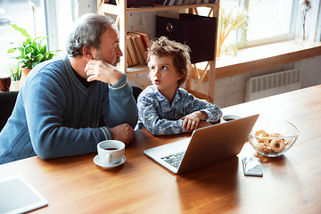 Image showing Grandfather and his grandson spending time insulated at home, stadying, watching cinema, shopping together