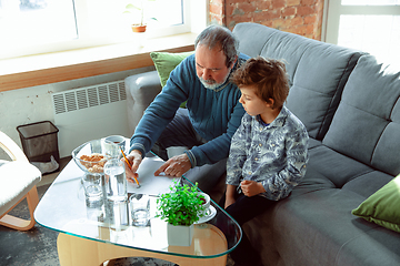 Image showing Grandfather and his grandson spending time insulated at home, stadying, writing, drawing or playing together