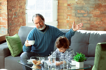 Image showing Grandfather and his grandson spending time insulated at home, stadying, writing, drawing or playing together