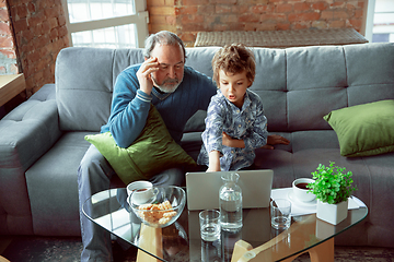 Image showing Grandfather and his grandson spending time insulated at home, stadying, watching cinema, shopping together