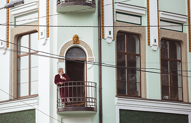 Image showing Mature senior older man during quarantine, realizing how important stay at home during virus outbreak, drinking coffee on the balcony