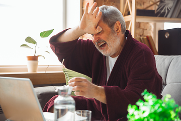 Image showing Mature senior older man during quarantine, realizing how important stay at home during virus outbreak, suffers of glaucoma, eye deseases