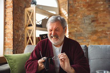 Image showing Mature senior older man during quarantine, realizing how important stay at home during virus outbreak, suffers of glaucoma, eye deseases