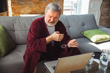 Image showing Mature senior older man during quarantine, realizing how important stay at home during virus outbreak, suffers of glaucoma, eye deseases