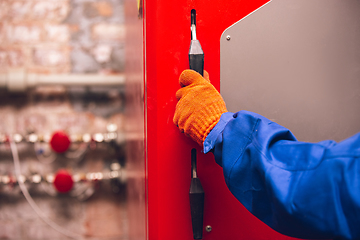 Image showing Close up of hands of repairman, professional builder working outdoors, repairing