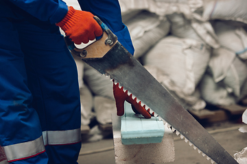 Image showing Close up of hands of repairman, professional builder working outdoors, repairing