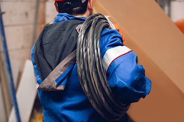 Image showing Close up of hands of repairman, professional builder working outdoors, repairing