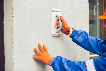 Image showing Close up of hands of repairman, professional builder working outdoors, repairing