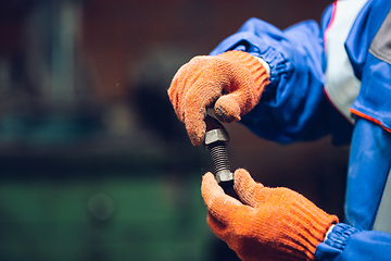 Image showing Close up of hands of repairman, professional builder working outdoors, repairing