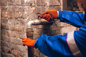 Image showing Close up of hands of repairman, professional builder working outdoors, repairing