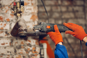 Image showing Close up of hands of repairman, professional builder working outdoors, repairing