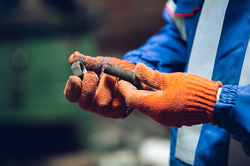 Image showing Close up of hands of repairman, professional builder working outdoors, repairing