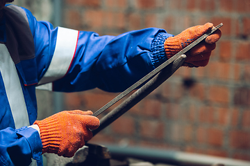 Image showing Close up of hands of repairman, professional builder working outdoors, repairing