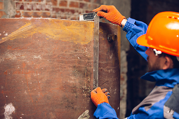 Image showing Close up of hands of repairman, professional builder working outdoors, repairing