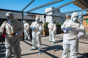 Image showing Coronavirus Pandemic. A disinfectors in a protective suit and mask spray disinfectants in the house or office