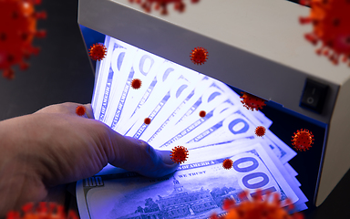 Image showing Male hands checking of banknotes in the detector, 3D models of coronavirus spreding around