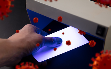 Image showing Male hands checking of banknotes in the detector, 3D models of coronavirus spreding around