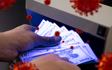 Image showing Male hands checking of banknotes in the detector, 3D models of coronavirus spreding around