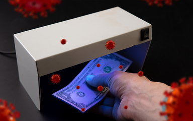 Image showing Male hands checking of banknotes in the detector, 3D models of coronavirus spreding around