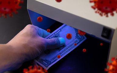 Image showing Male hands checking of banknotes in the detector, 3D models of coronavirus spreding around