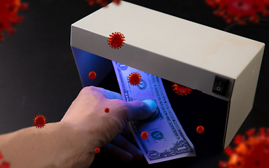 Image showing Male hands checking of banknotes in the detector, 3D models of coronavirus spreding around