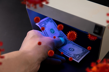 Image showing Male hands checking of banknotes in the detector, 3D models of coronavirus spreding around