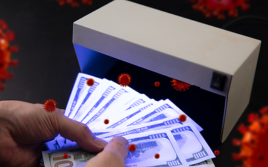 Image showing Male hands checking of banknotes in the detector, 3D models of coronavirus spreding around