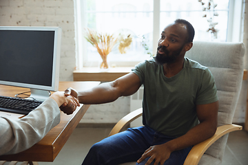 Image showing Young man sitting in office during the job interview with female employee, boss or HR-manager, talking, thinking, looks confident