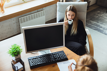 Image showing Young woman sitting in office during the job interview with female employee, boss or HR-manager, talking, thinking, looks confident