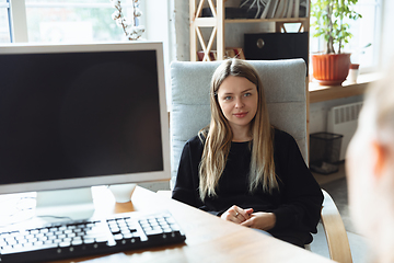 Image showing Young woman sitting in office during the job interview with female employee, boss or HR-manager, talking, thinking, looks confident