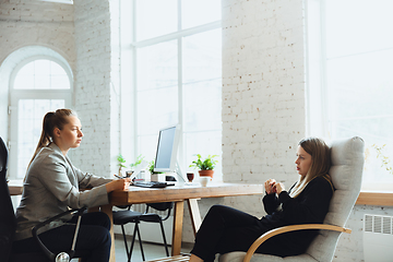 Image showing Young woman sitting in office during the job interview with female employee, boss or HR-manager, talking, thinking, looks confident