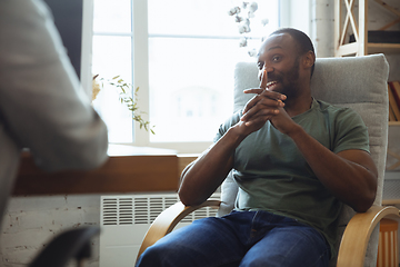 Image showing Young man sitting in office during the job interview with female employee, boss or HR-manager, talking, thinking, looks confident