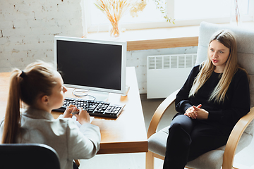 Image showing Young woman sitting in office during the job interview with female employee, boss or HR-manager, talking, thinking, looks confident