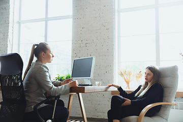 Image showing Young woman sitting in office during the job interview with female employee, boss or HR-manager, talking, thinking, looks confident