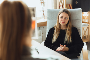 Image showing Young woman sitting in office during the job interview with female employee, boss or HR-manager, talking, thinking, looks confident