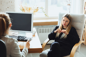 Image showing Young woman sitting in office during the job interview with female employee, boss or HR-manager, talking, thinking, looks confident