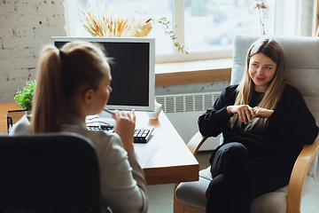 Image showing Young woman sitting in office during the job interview with female employee, boss or HR-manager, talking, thinking, looks confident