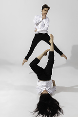 Image showing Young and graceful ballet dancers in minimal black style isolated on white studio background