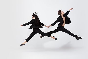 Image showing Young and graceful ballet dancers in minimal black style isolated on white studio background