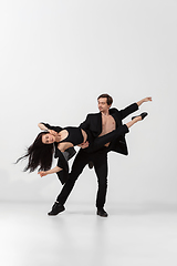 Image showing Young and graceful ballet dancers in minimal black style isolated on white studio background