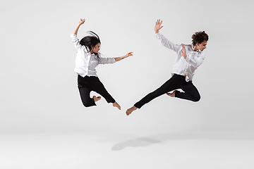 Image showing Young and graceful ballet dancers in minimal black style isolated on white studio background